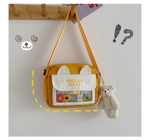 Detail of yellow girl's crossbody bag with cat ear design and transparent PVC pocket