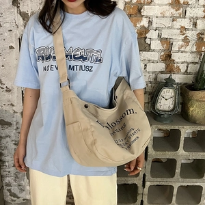 Large beige canvas tote bag with 'Blossom morning' text shown against a red brick wall