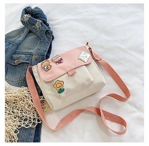 Détail d'un petit sac bandoulière en toile avec des broderies de dessins animés mignons