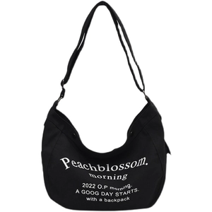 Minimalist black canvas hobo bag with white typography print and adjustable shoulder strap