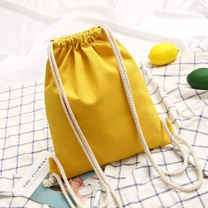 Minimalist bright yellow canvas drawstring backpack with white cotton straps for casual use