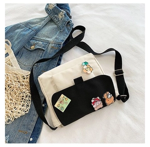 Détail du sac bandoulière en toile avec badges mignons et rabat contrasté