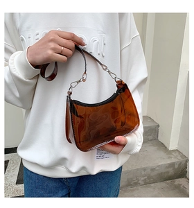 Detail view of amber brown translucent PVC jelly bag with black zipper and silver hardware