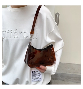 Detailed view of the brown transparent jelly PVC shoulder bag with polished strap