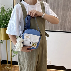 Blue mini canvas crossbody bag with white flap, cute bear pendant, and adjustable strap