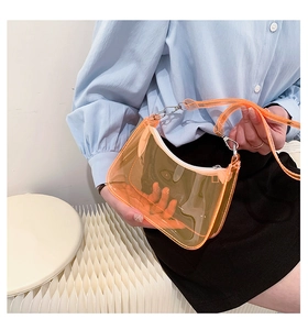 Orange translucent PVC baguette bag worn by a model, featuring white zipper and silver hardware