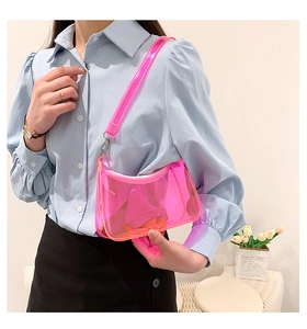 Close-up of translucent pink jelly PVC baguette bag worn as an underarm shoulder bag