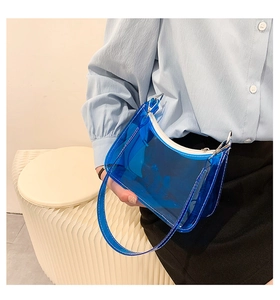 Close-up of a blue transparent PVC shoulder bag with white stitching and silver hardware