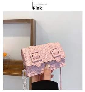 Gros plan d'un mini sac tissé rose avec chaîne acrylique et bandoulière assortie