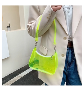 Neon green transparent PVC baguette bag worn by a model in a stylish street setting