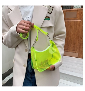Detail shot of neon yellow clear PVC shoulder bag with silver hardware and hobo design