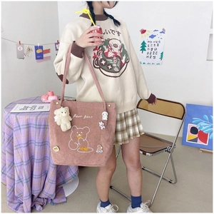 Détail du sac cabas en velours rose avec broderie ours et badges de dessins animés mignons
