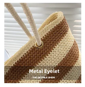 Detailed macro view of woven straw tote bag with metal eyelets and rope handles