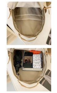 Detail showing the large capacity main compartment of the beige backpack with pockets