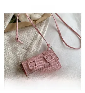 Détail du sac bandoulière rose tissé avec chaîne en acrylique et doubles anneaux décoratifs