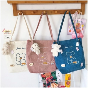 Détails de la texture velours et broderie ours sur des sacs cabas décontractés