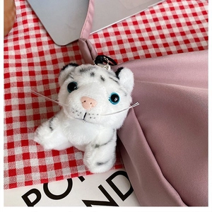 Detailed shot of a white plush tiger keychain with blue eyes and black tiger stripes