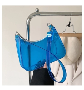 Detail of blue transparent PVC shoulder bag with white stitching and silver metal hook