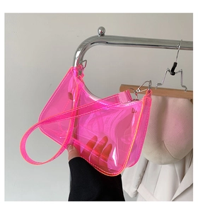 Detailed macro shot of a neon pink transparent PVC handbag with silver metal buckle details
