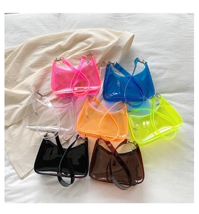 Flat lay of colorful PVC jelly baguette bags in seven vibrant candy colors on fabric