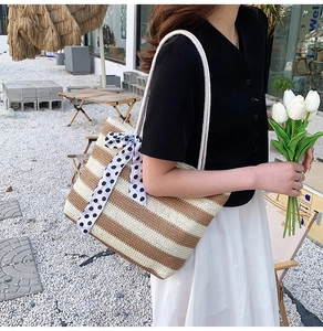Close-up of woven straw tote bag with brown stripes and a polka dot ribbon bow