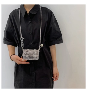 Gros plan sur un mini sac bandoulière en tweed gris avec chaîne acrylique et boucles