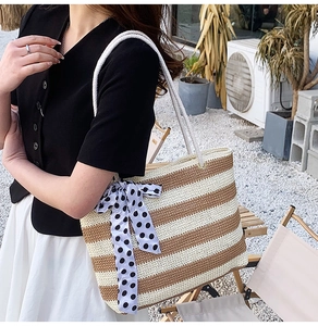 Detail of woven tote bag featuring thick cotton rope handles and a blue polka dot scarf