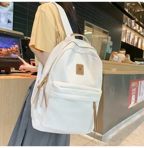 Minimalist white nylon backpack for women being worn in a casual daily lifestyle setting