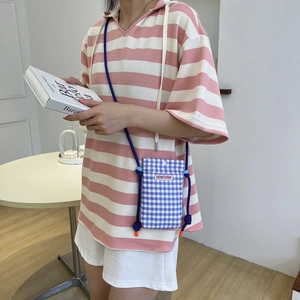 Mini sac à bandoulière à carreaux bleus et blancs avec cordon violet sur polo rayé