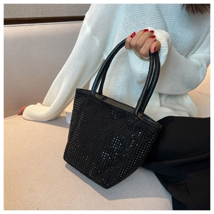 Close-up of black rhinestone tote bag held by a model for a chic summer look