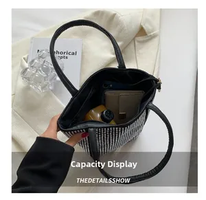 Muestra de capacidad del bolso negro con pedrería con espacio para móvil y cartera