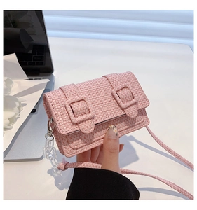 Gros plan détaillé du mini sac bandoulière en tweed rose avec chaîne acrylique et boucles