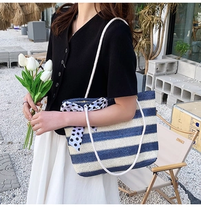 Detail of blue and white striped woven tote bag with rope handles and polka dot bow
