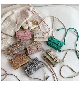 Mini sacs carrés en tweed coloré avec chaînes acryliques sur fond de lin blanc doux