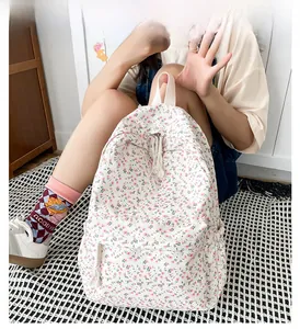 Detail view of a floral canvas backpack with multi-pocket design and flower patterns