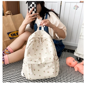 Detailed macro view of beige canvas backpack with sweet floral pattern and zipper pockets