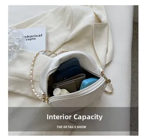 Internal capacity view of white round quilted crossbody bag with daily essentials inside