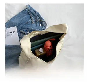 Detail view of large canvas tote bag showing interior capacity with tablet and umbrella