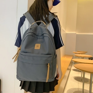 Minimalist nylon backpack with gray fabric and leather trim details for women and students