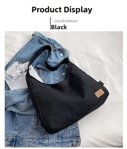 Detail of black canvas tote bag showing brown leather SPORT patch and MAXUX side label