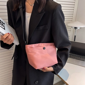 Minimalist pink nylon shoulder bag with adjustable black strap and snap closure