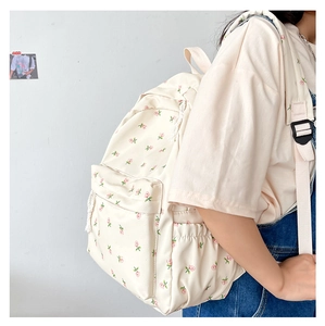 Detail view of cream canvas backpack with pink rose floral print on a female model