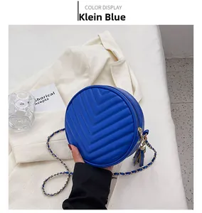 Close-up of Klein Blue round crossbody bag with V-quilted pattern and leather chain strap