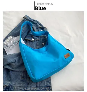 Detail of the blue canvas tote bag showing the textured fabric and SPORT leather label