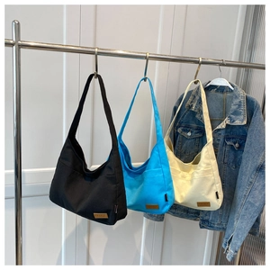 Close-up of durable canvas tote bags in black, blue and beige with SPORT label detail