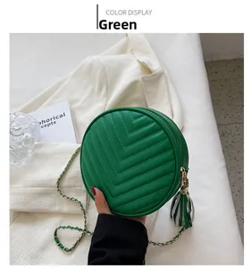 Detail shot of green circular quilted bag with V-stitch and fringe tassel accent