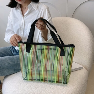 Détail d'un grand sac fourre-tout en maille rayée colorée porté pour un style d'été