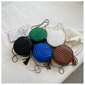 Detailed view of colorful V-quilted circular crossbody bags with metal chain straps
