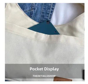 Detail showing front pocket of canvas tote bag storing a tablet for daily utility