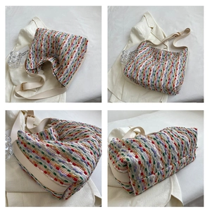 Macro detail of multi-color woven tote bag with adjustable cream leather shoulder strap